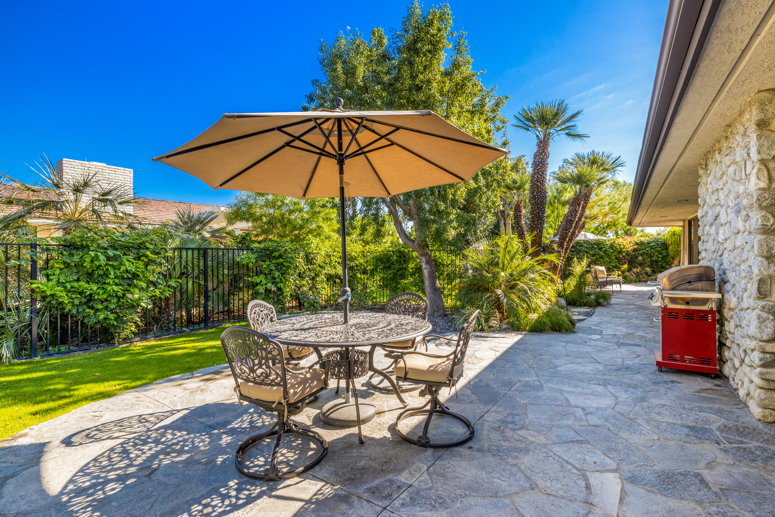 15 Johnar Boulevard Rancho Mirage, CA 92270 - Photo 50 of 68 a view of a backyard with table and chairs under an umbrella