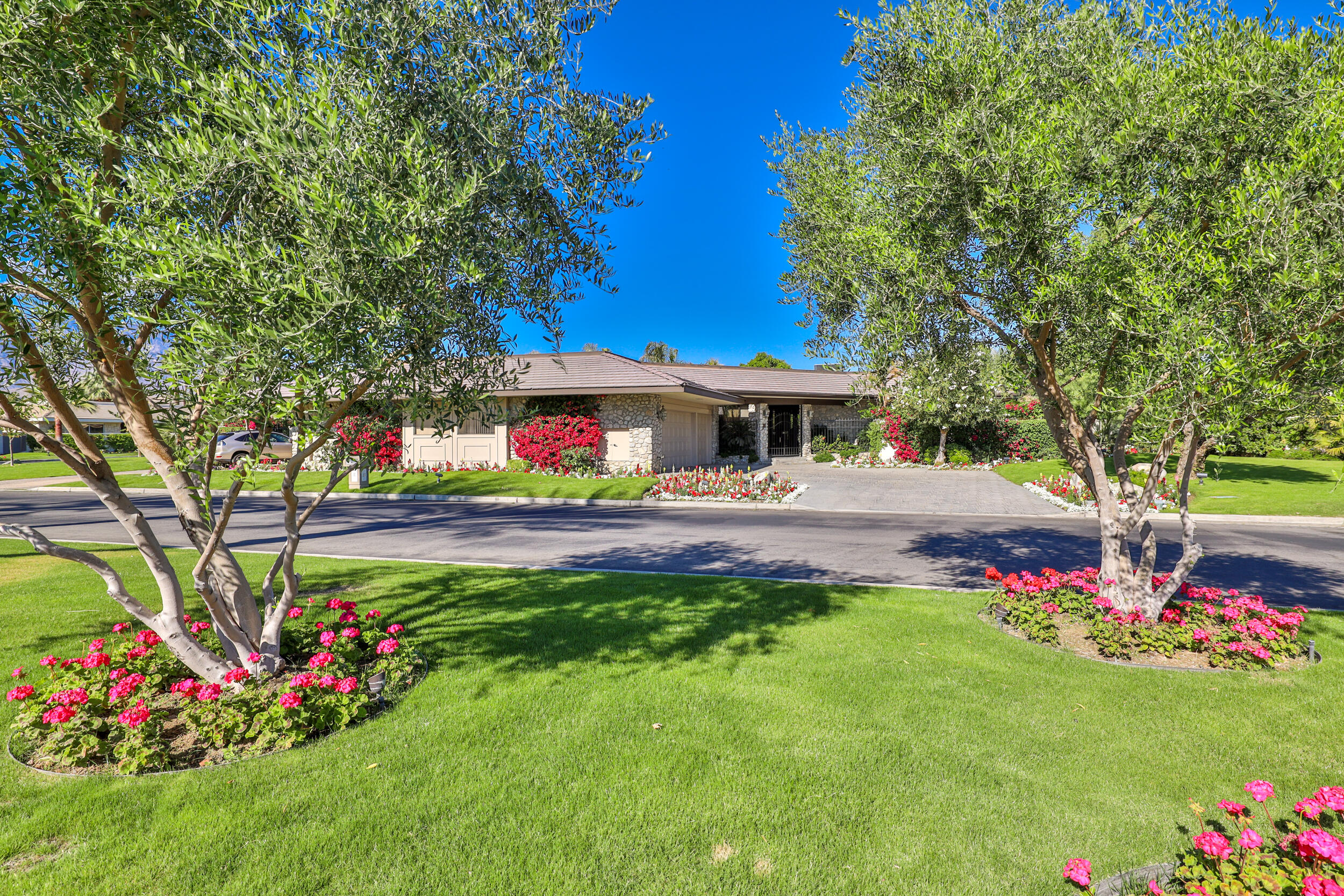 15 Johnar Boulevard Rancho Mirage, CA 92270 - Photo 6 of 68 a view of a house with a big yard potted plants and large tree