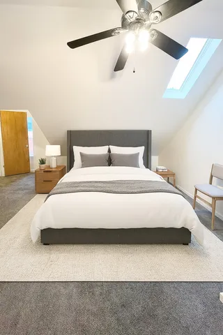 a bedroom with a bed and a ceiling fan