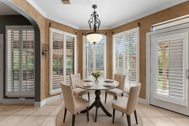a dining room with furniture and large windows
