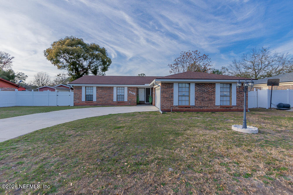 8209 Worm Wood Road Jacksonville, FL 32210 - Photo 11 of 44 a view of a yard in front of a house with large tree