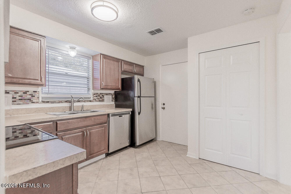 8209 Worm Wood Road Jacksonville, FL 32210 - Photo 18 of 44 a kitchen with a sink stove and refrigerator