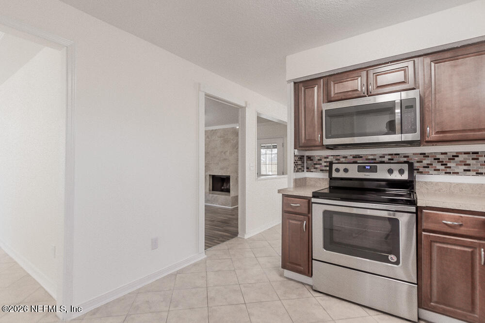 8209 Worm Wood Road Jacksonville, FL 32210 - Photo 19 of 44 a kitchen with cabinets stainless steel appliances and a counter top space