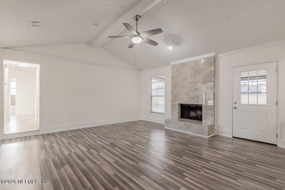 8209 Worm Wood Road Jacksonville, FL 32210 - Photo 2 of 44 an empty room with wooden floor fireplace and windows