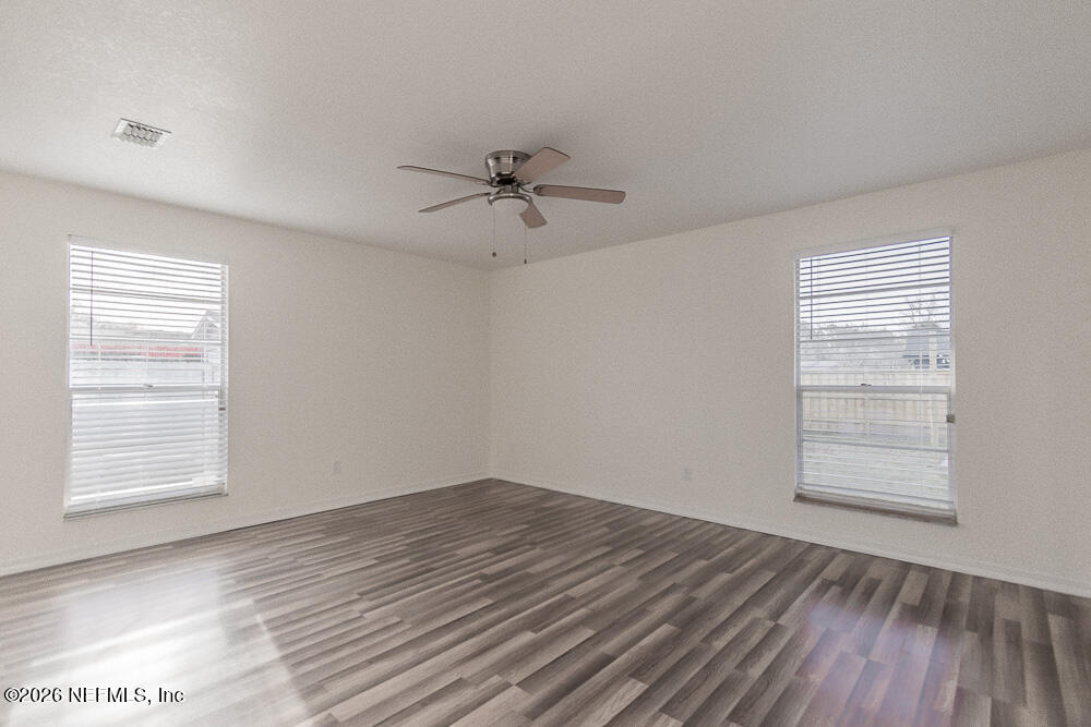 8209 Worm Wood Road Jacksonville, FL 32210 - Photo 25 of 44 a view of empty room with wooden floor and fan
