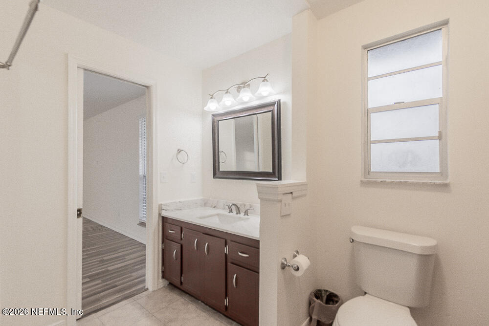 8209 Worm Wood Road Jacksonville, FL 32210 - Photo 27 of 44 a bathroom with a toilet sink and mirror