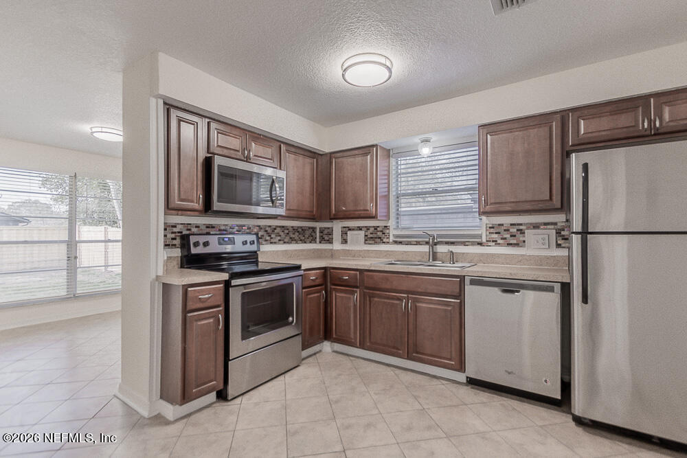 8209 Worm Wood Road Jacksonville, FL 32210 - Photo 3 of 44 a kitchen with stainless steel appliances granite countertop a refrigerator stove a sink and dishwasher
