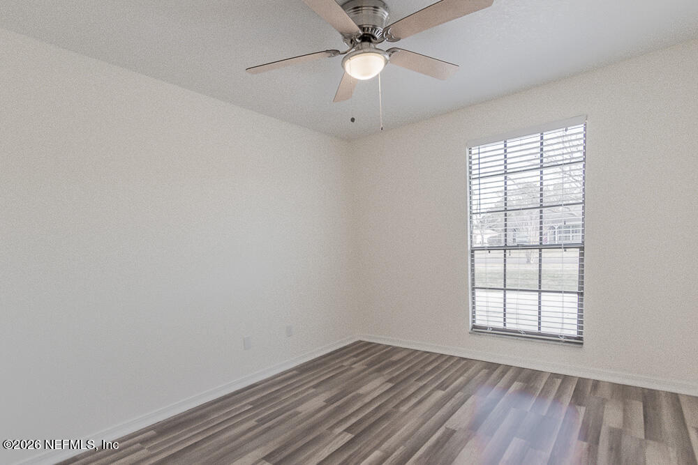 8209 Worm Wood Road Jacksonville, FL 32210 - Photo 32 of 44 an empty room with a window and wooden floor