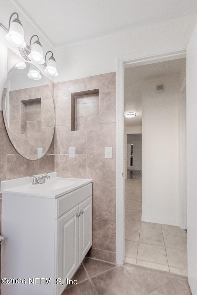 8209 Worm Wood Road Jacksonville, FL 32210 - Photo 34 of 44 a bathroom with a sink a vanity a mirror and a shower
