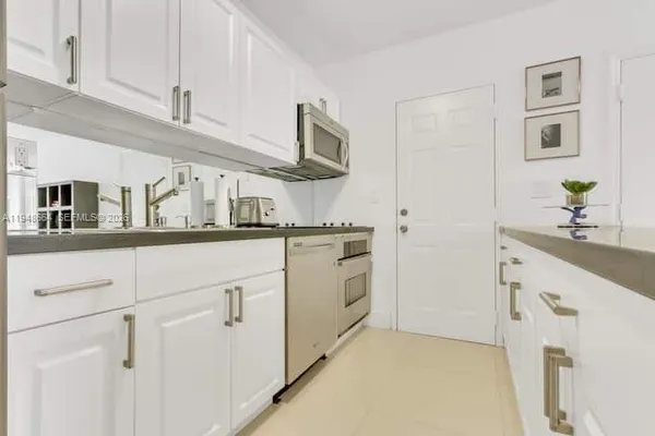 a kitchen with cabinets stainless steel appliances and a counter space
