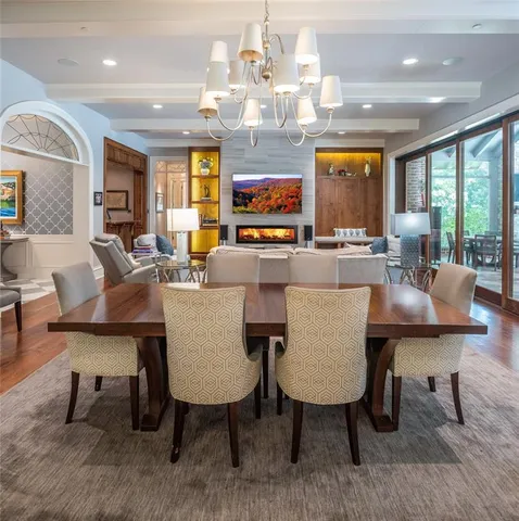a view of a dining room with furniture a chandelier and wooden floor
