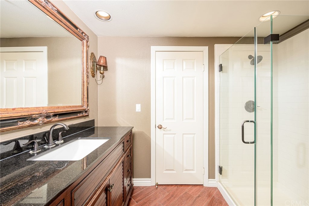 2243 Martin, Unit 409 Irvine, CA 92612 - Photo 18 of 43 a bathroom with a granite countertop sink a mirror and a shower