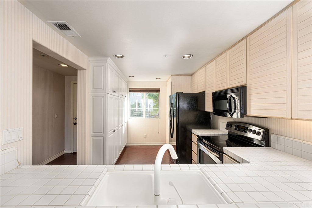 2243 Martin, Unit 409 Irvine, CA 92612 - Photo 4 of 43 a living room with stainless steel appliances kitchen island granite countertop a refrigerator and a sink