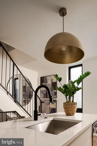 a closeup of a sink with potted plants and large mirror