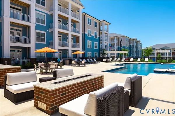a swimming pool with outdoor seating and a yard