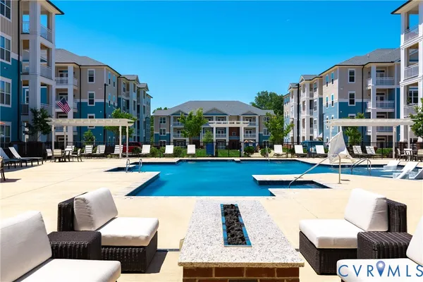 a view of a building with swimming pool and sitting area