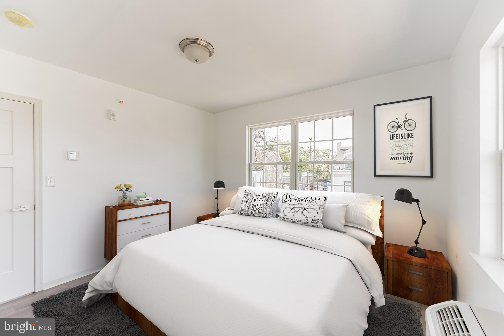 7105 Ridge Avenue, Unit B4 Philadelphia, PA 19128 - Photo 3 of 6 a bedroom with a bed and wooden floor