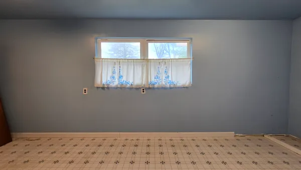 a view of a room with wooden floor and a window