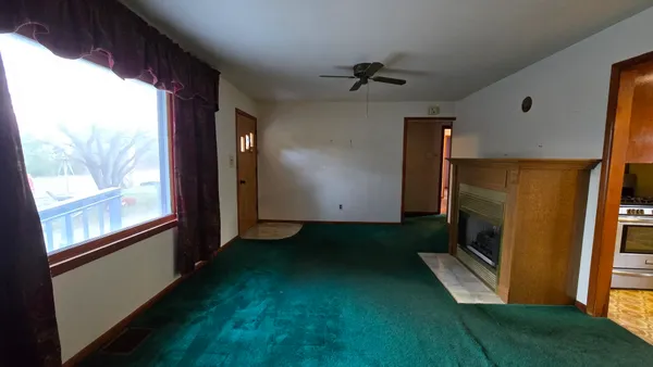 a view of a room with wooden floor and windows