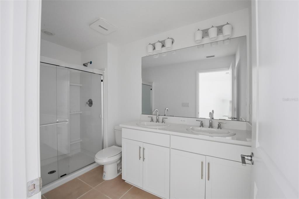 2407 Paravane Way Wesley Chapel, FL 33543 - Photo 14 of 32 a bathroom with a granite countertop sink a toilet and shower