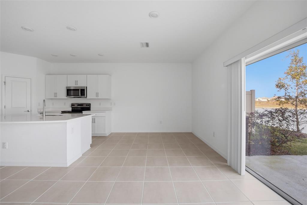 2407 Paravane Way Wesley Chapel, FL 33543 - Photo 3 of 32 a kitchen with granite countertop white cabinets and white appliances