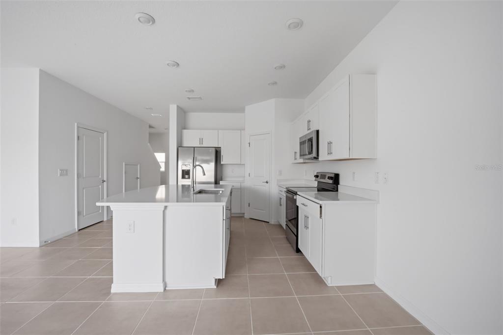 2407 Paravane Way Wesley Chapel, FL 33543 - Photo 6 of 32 a kitchen with stainless steel appliances a refrigerator sink and cabinets