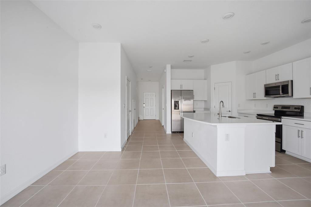 2407 Paravane Way Wesley Chapel, FL 33543 - Photo 8 of 32 a large white kitchen with a stove a sink dishwasher and a refrigerator with white cabinets