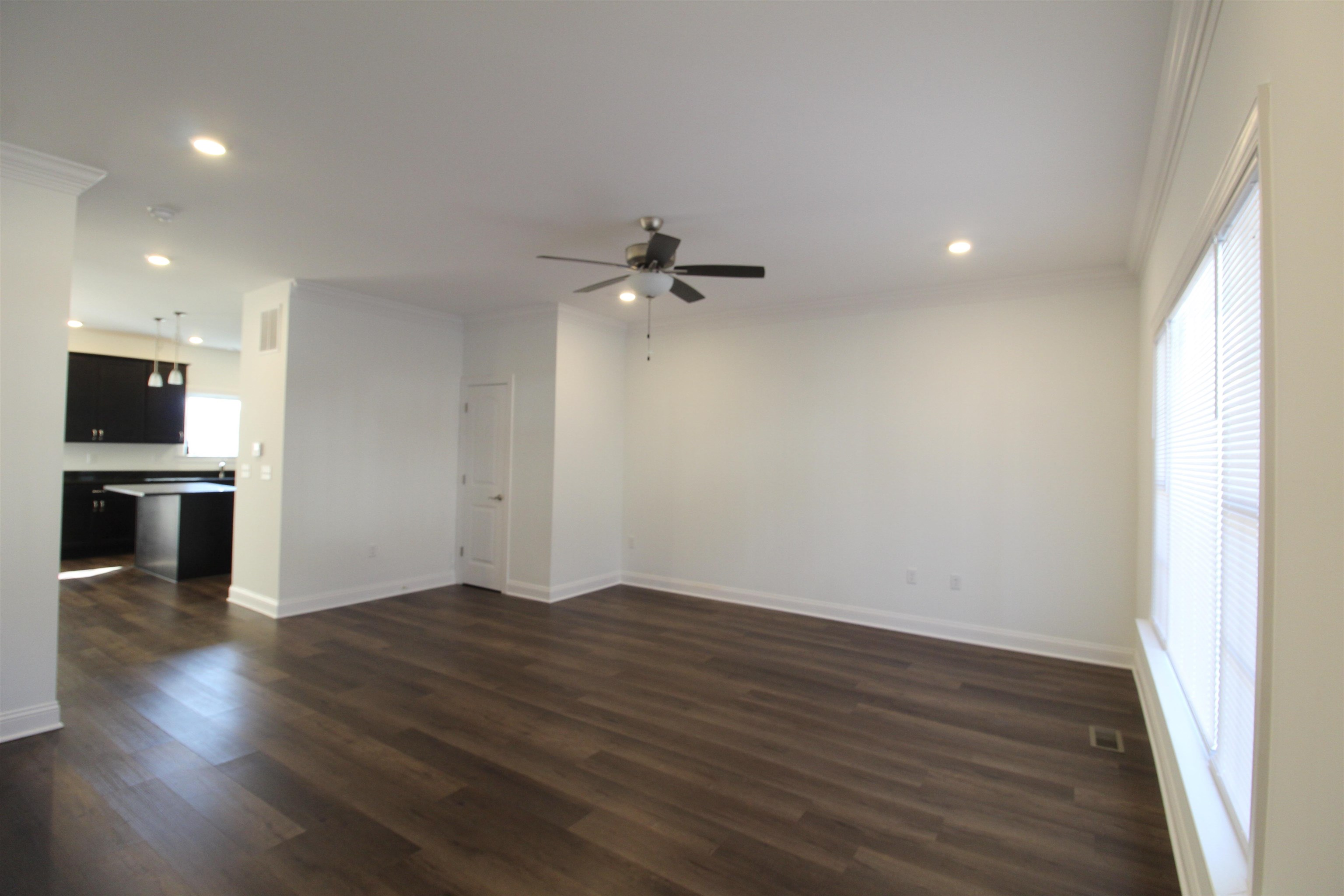 1145 Bluemoon Drive Harrisonburg, VA 22801 - Photo 5 of 18 an empty room with wooden floor and a kitchen