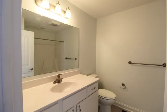 a bathroom with a sink toilet and a mirror