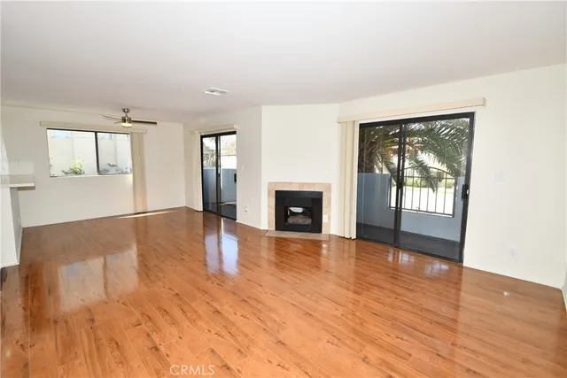 an empty room with wooden floor and a fireplace