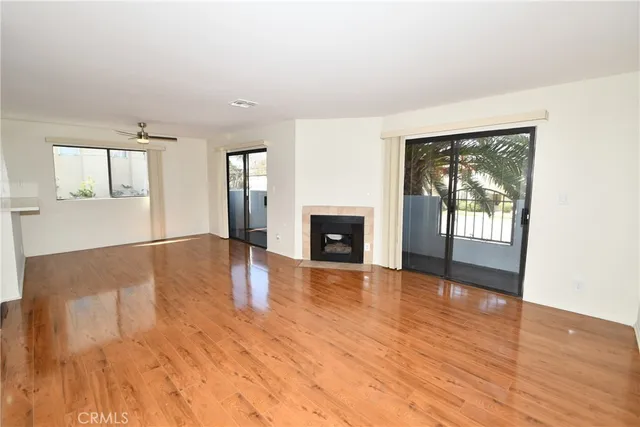 an empty room with wooden floor and a fireplace