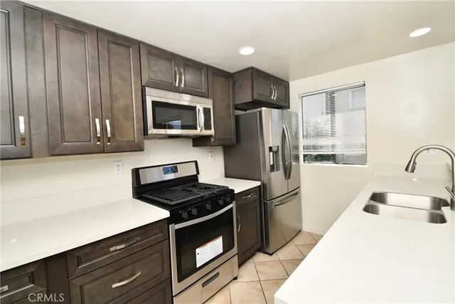 a kitchen with granite countertop a refrigerator stove and microwave