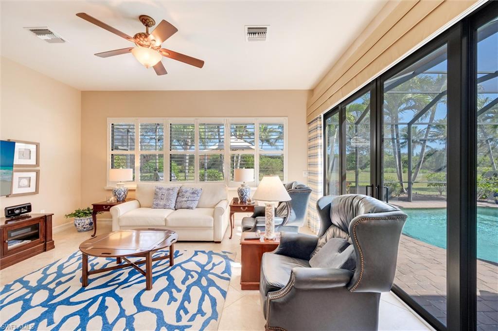 7660 Cottesmore Drive Naples, FL 34113 - Photo 16 of 50 a living room with furniture and a large window