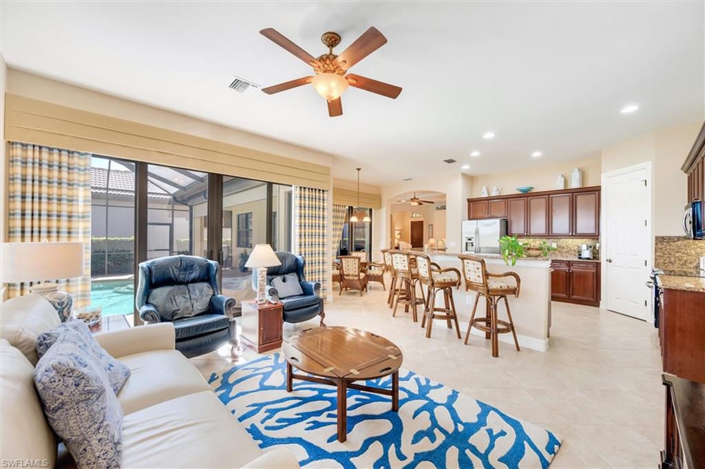 7660 Cottesmore Drive Naples, FL 34113 - Photo 2 of 50 a living room with furniture and a large window with wooden floor