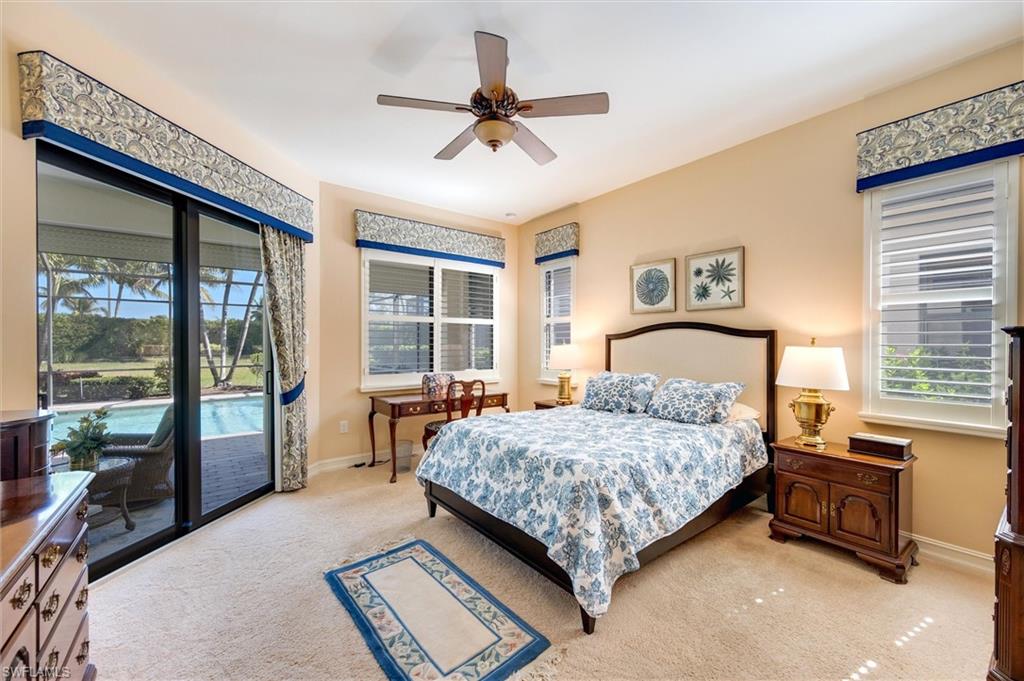 7660 Cottesmore Drive Naples, FL 34113 - Photo 30 of 50 a bedroom with a bed and a large window with the outer view