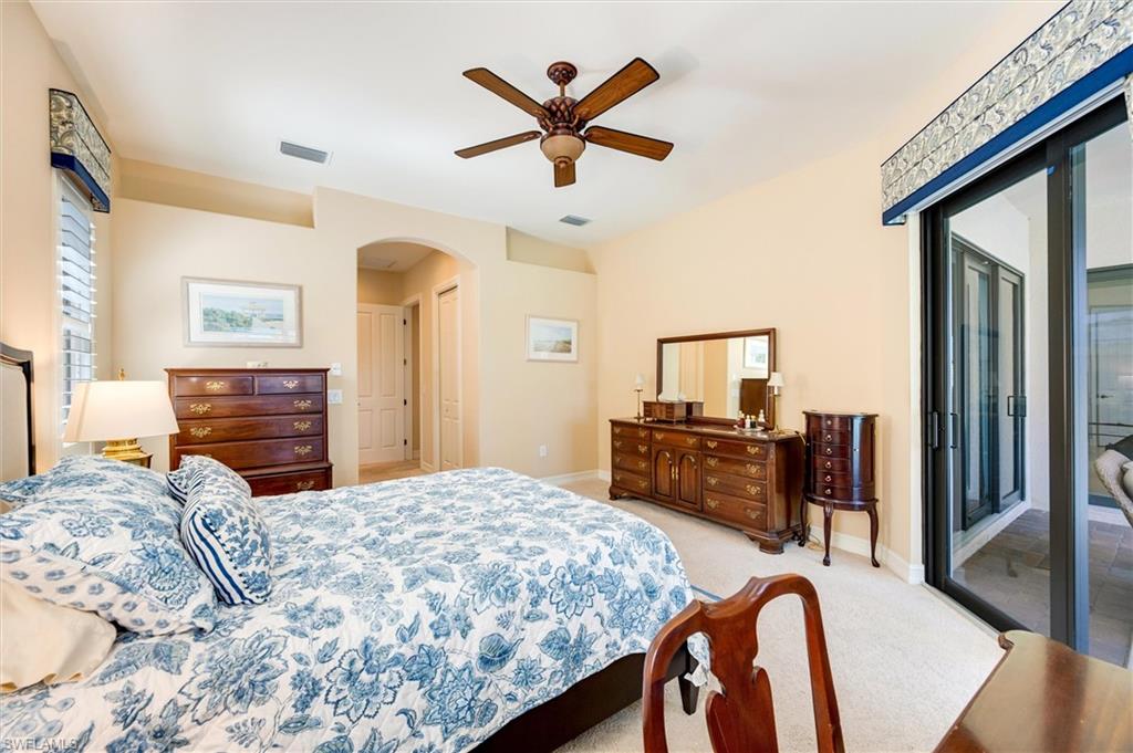 7660 Cottesmore Drive Naples, FL 34113 - Photo 31 of 50 a bedroom with a bed and dresser with mirror