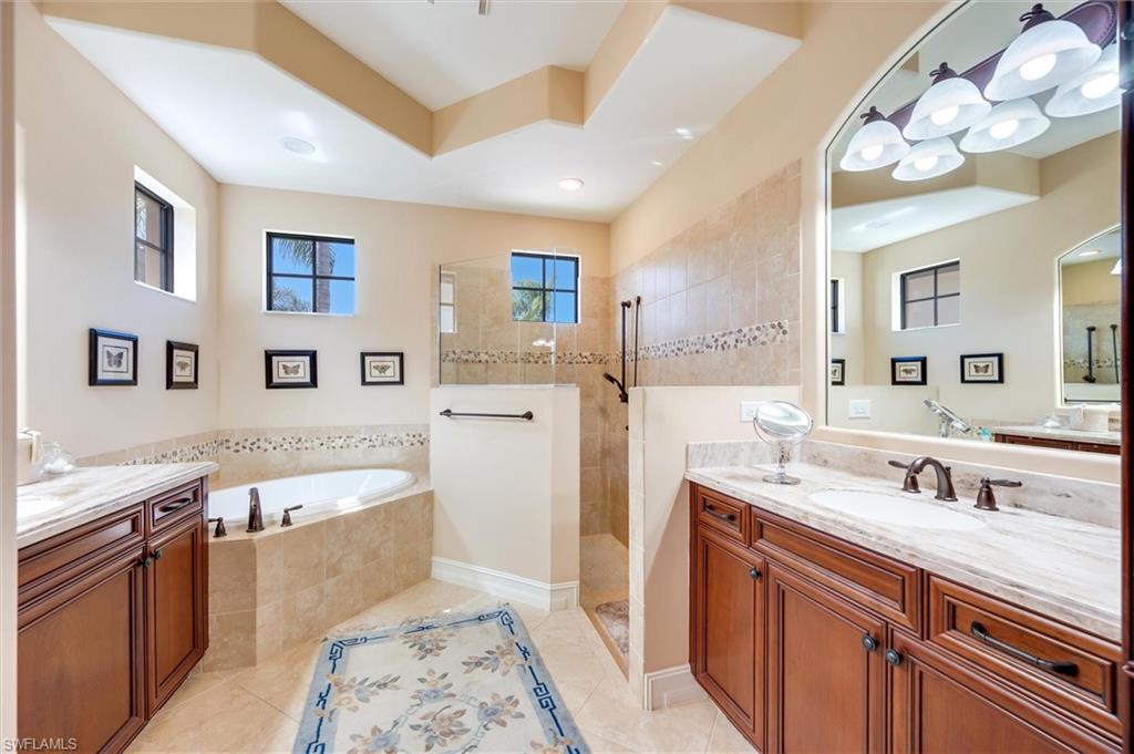 7660 Cottesmore Drive Naples, FL 34113 - Photo 32 of 50 a spacious bathroom with a tub double sink and a mirror