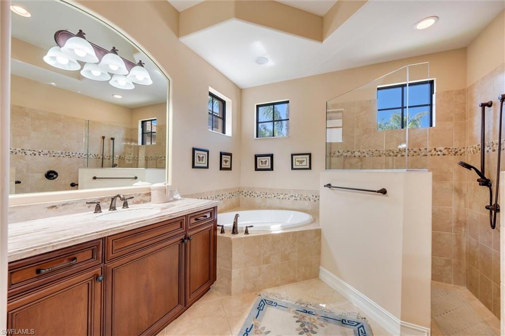 7660 Cottesmore Drive Naples, FL 34113 - Photo 33 of 50 a spacious bathroom with a tub sink and mirror