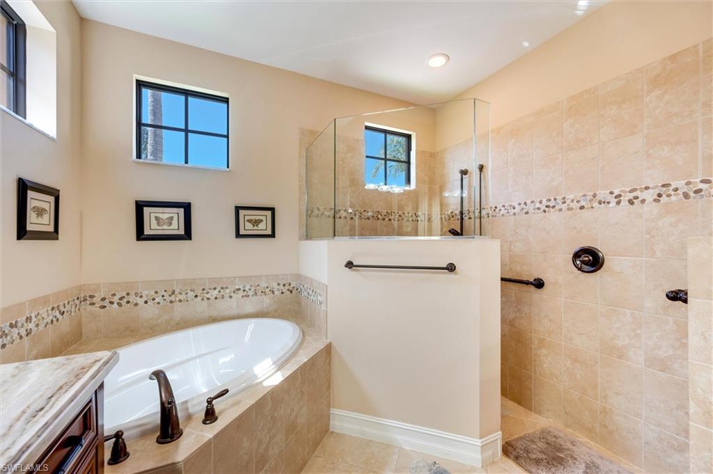 7660 Cottesmore Drive Naples, FL 34113 - Photo 34 of 50 a bathroom with a tub a sink and a window