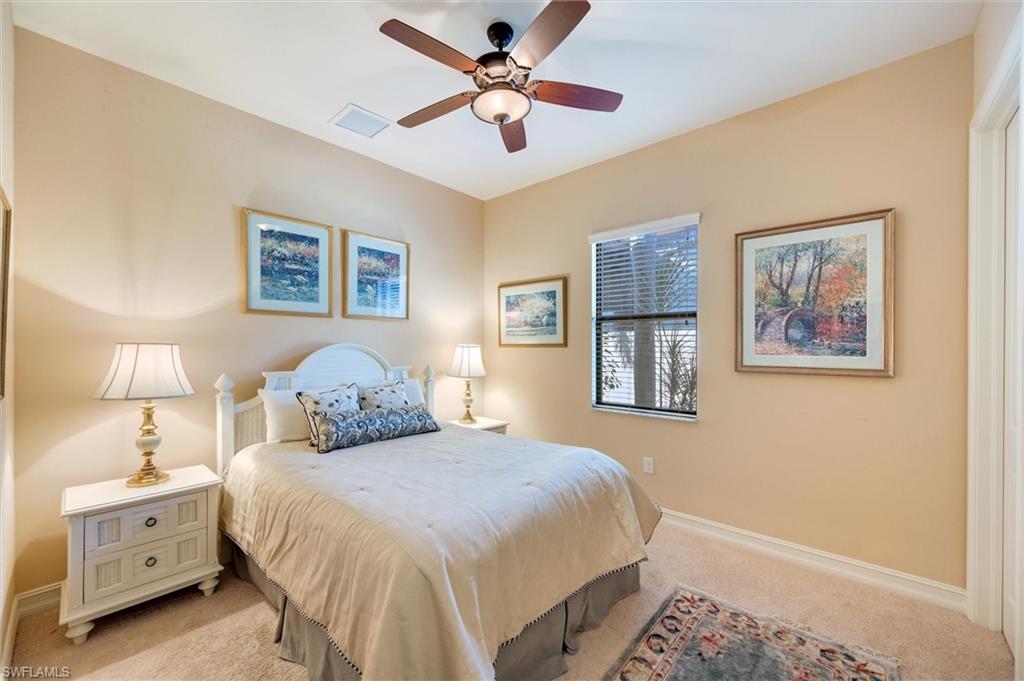 7660 Cottesmore Drive Naples, FL 34113 - Photo 35 of 50 a bedroom with a bed and a lamp on a dresser