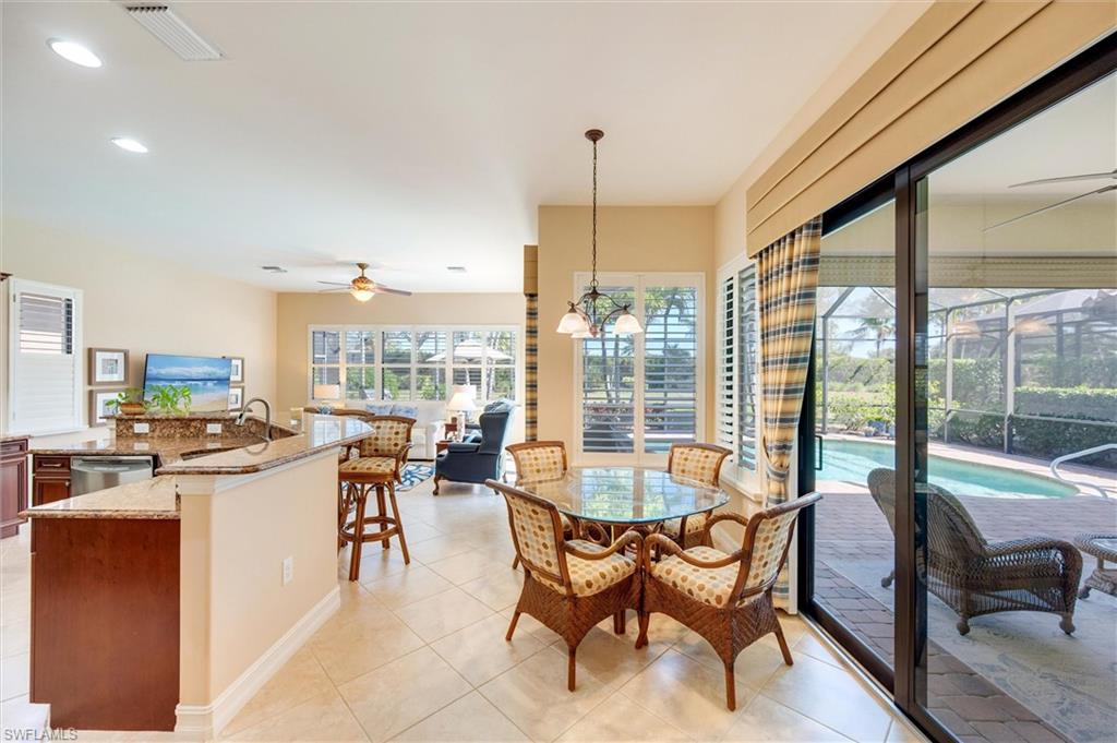7660 Cottesmore Drive Naples, FL 34113 - Photo 8 of 50 a dining room with stainless steel appliances granite countertop a stove and a dining table chair