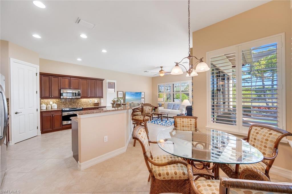 7660 Cottesmore Drive Naples, FL 34113 - Photo 10 of 50 a kitchen with kitchen island a large window in it