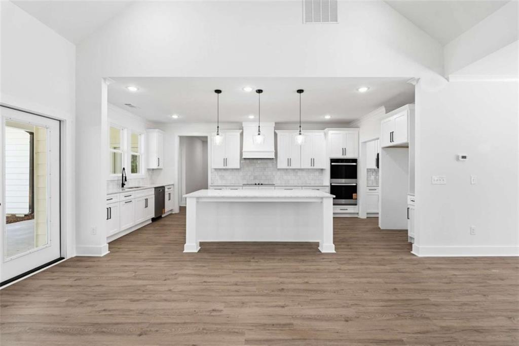 11691 Hazelbrand Road Northeast Covington, GA 30014 - Photo 11 of 53 a large kitchen with stainless steel appliances kitchen island large windows and cabinets