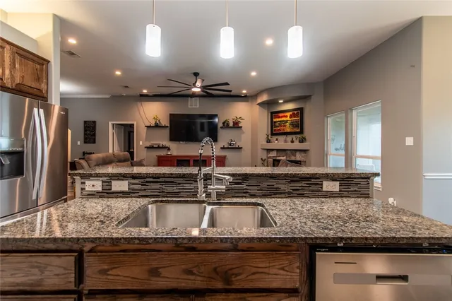 a kitchen with kitchen island granite countertop a sink counter top stainless steel appliances and cabinets