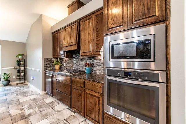 a kitchen with stainless steel appliances granite countertop a stove microwave and cabinets
