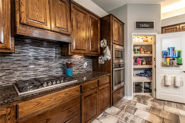 a kitchen with stainless steel appliances granite countertop a stove and a refrigerator