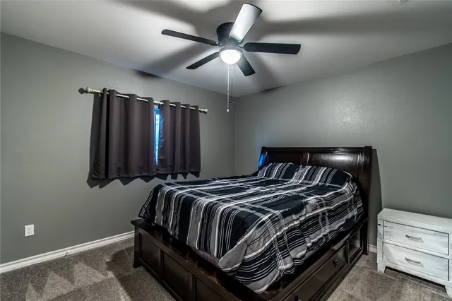 a bed room with a bed and a ceiling fan