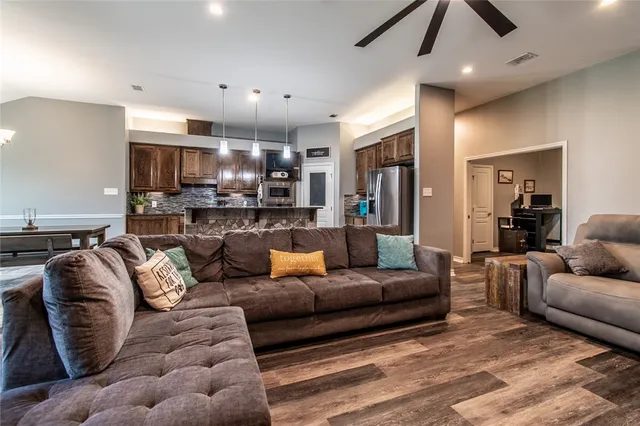 a living room with furniture kitchen and a chandelier