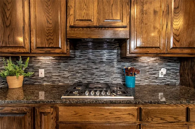 a kitchen with stainless steel appliances granite countertop a stove a sink and a microwave