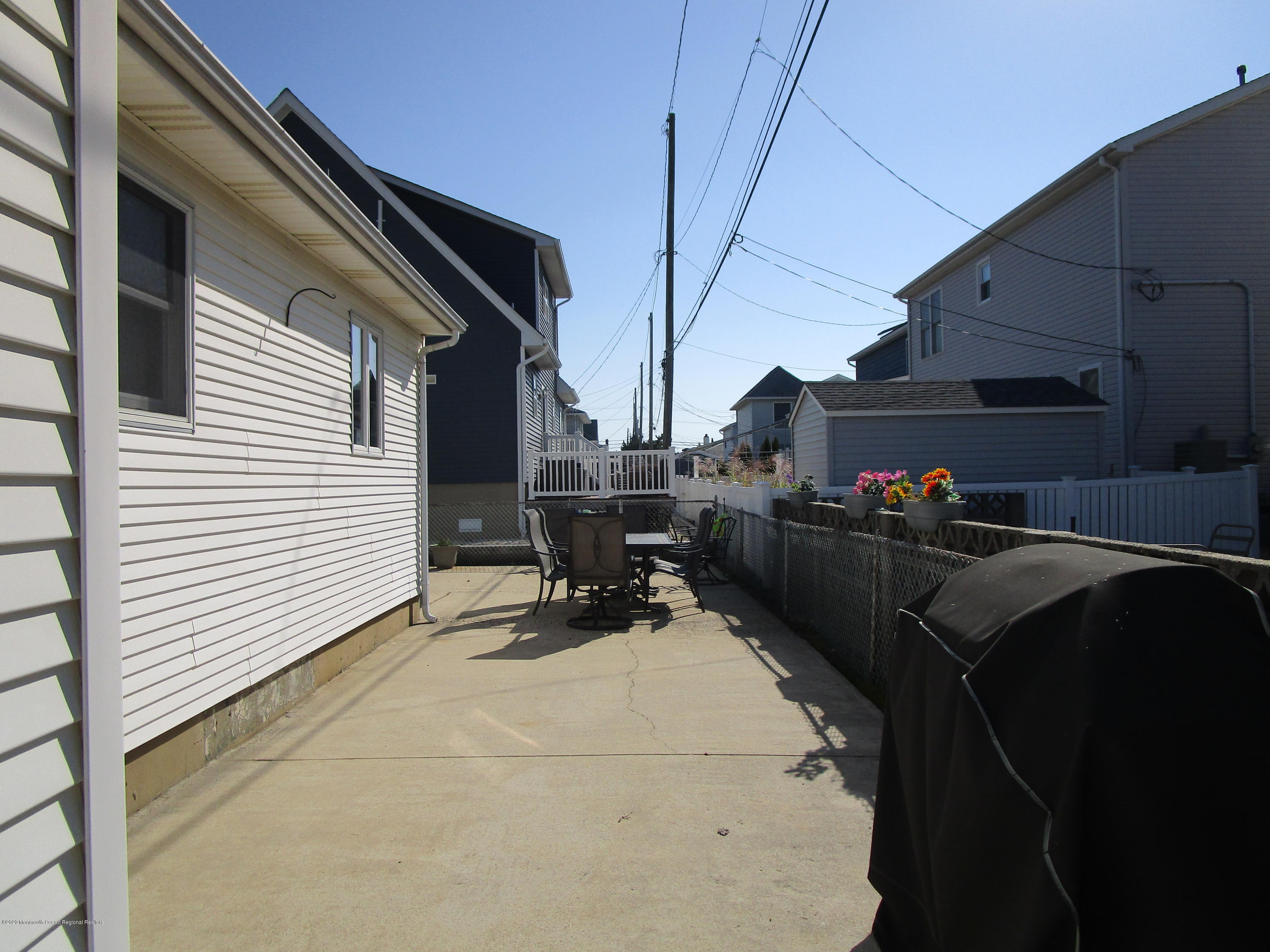 121 Jacobsen Lane Lavallette, NJ 08735 - Photo 14 of 19 a roof deck with table and chairs and potted plants